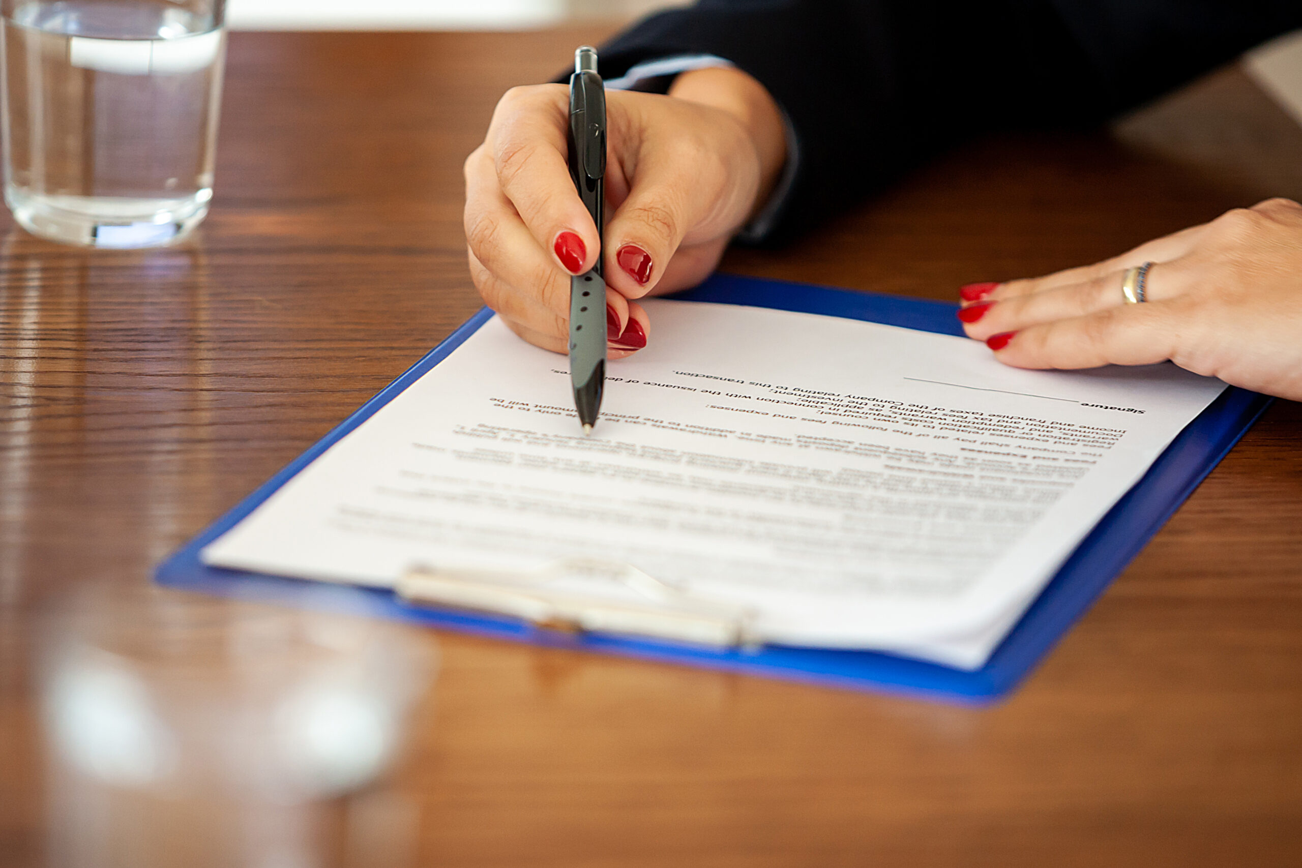 Hand of businesswoman signing a contract in the meetinf room