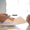 handing over pen and paper